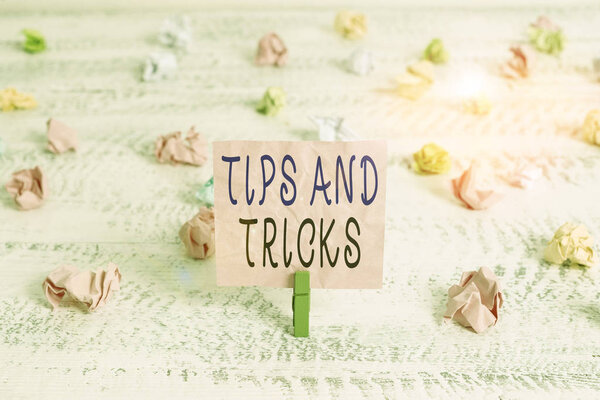 Handwriting text Tips And Tricks. Conceptual photo piece of inside facts specially in betting or investing Green clothespin white wood background colored paper reminder office supply