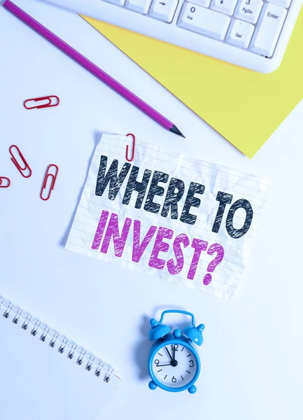 Text sign showing Where To Invest Question. Business photo text asking where put money into financial schemes or shares Flat lay above white blank paper with copy space for text messages