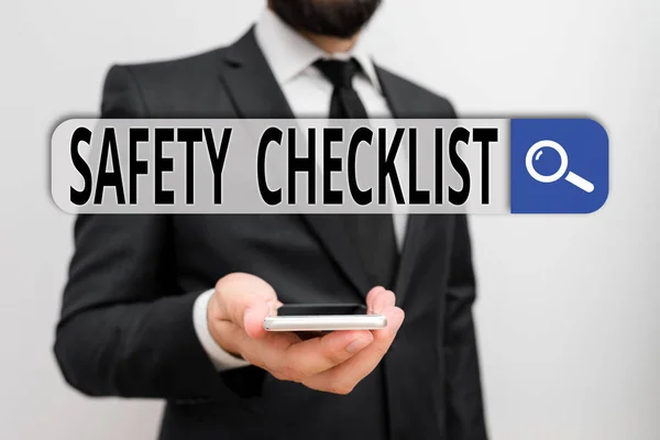 Writing note showing Safety Checklist. Business concept for list of items you need to verify, check or inspect Male human wear formal work suit hold smartphone using hand