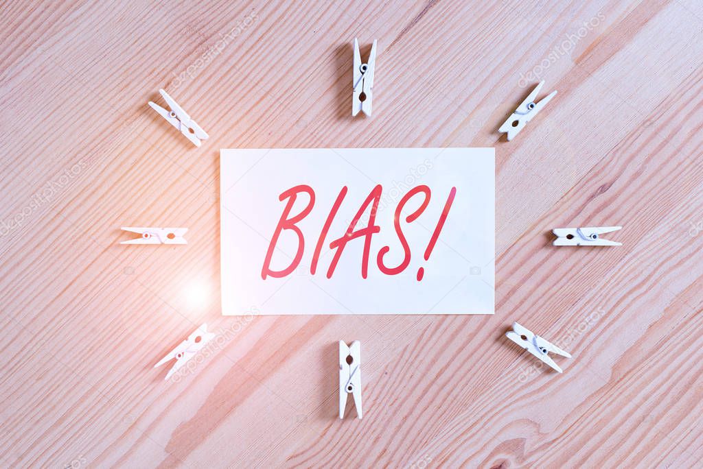 Text sign showing Bias. Business photo showcasing inclination or prejudice for or against one demonstrating group Colored clothespin papers empty reminder wooden floor background office
