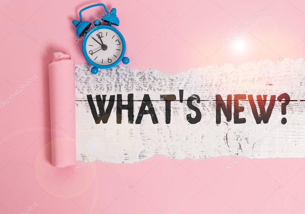 Text sign showing What S New Question. Business photo showcasing when you ask someone about his current live events actions Alarm clock and torn cardboard placed above a wooden classic table backdrop