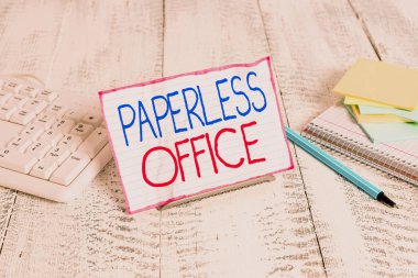 Evraksız Ofis 'i gösteren bir not yazıyorum. Kağıt kullanımının kaldırıldığı çalışma ortamı için iş konsepti bilgisayar klavyesi ve kağıtlar arasında tel üzerine not kağıdı