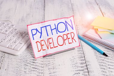 Python Geliştiricisini gösteren not yazılıyor. Serverside web uygulama mantığının yazılmasından sorumlu iş konsepti bilgisayar klavyesi ve sayfaların arasına tel üzerine not kağıdı