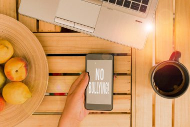 Kelime yazma metni Zorbalık yok. İş fotoğraflarının sergilenmesi çocuklar arasındaki agresif davranışları durdurur güç dengesizliği kadın bilgisayar akıllı telefon içki kupası ofisi teknolojik cihazlar sağlar