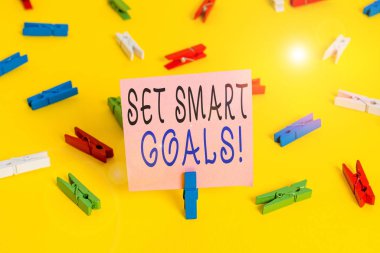 Akıllı Hedefleri Gösteren Metin İşareti. Fikirlerinizi netleştirmek için iş fotoğrafı gösterme listesi Odaklanma çabalarınızı akıllıca kullanın Renkli çamaşır iğnesi kağıtları boş hatırlatıcı sarı zemin arka plan ofisi