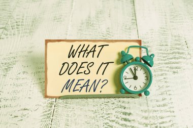 Ne anlama geldiğini gösteren bir not yazıyorum. Bana tanımlayıcı bir şeyin anlamını ver. Alarm saati tampon telin üzerine eğilmiş. Not kağıdının önünde.