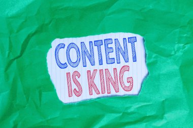 İçeriğin Kral olduğunu gösteren bir not yazıyorum. İçeriğin, yeşil buruşmuş renkli kağıdın renkli arka plan yırtılması ile ilgili bir web sitesinin başarısının merkezi olduğuna inanmak için iş kavramı
