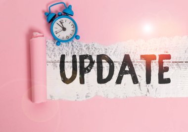 Güncelleme gösteren metin işareti. Yeni bilgi ekleyerek veya düzeltmeler yaparak iş fotoğrafı gösterimi Alarm saati ve yırtık karton parçalarını ahşap bir masa arkaplanının üzerine yerleştirerek