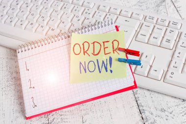 Order Now 'ı gösteren bir not yazıyorum. Bir partiden diğerine onaylanmış bir talep için iş konsepti. Not defteri hatırlatıcı broşlu, çivili, hafif ahşap.