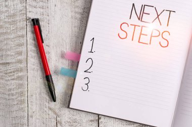 Sonraki Adımlar 'ı yazan el yazısı. Kavramsal fotoğraf bitirdikten sonra yaptığın ya da planladığın bir şey. Kalın sayfalar dizüstü bilgisayar, klasik ahşap arka plan.