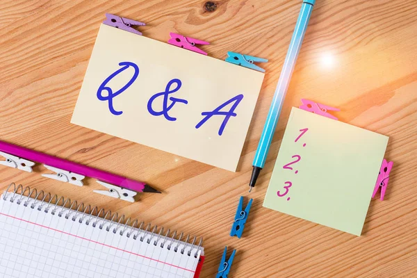QとAを示す概念的な手書き質問と回答として定義される概念的な意味色砕いた紙木製の床の背景の服ピン — ストック写真
