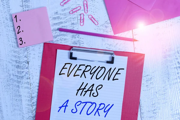誰もがストーリーを持っていることを示すメモを書く あなたの記憶物語を伝える背景物語のためのビジネスコンセプトクリップボード紙の鉛筆の封筒クリップノートパッド木製の背景 — ストック写真