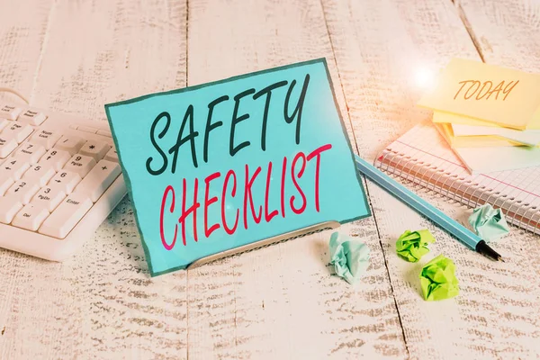 Handwriting text Safety Checklist. Conceptual photo list of items you need to verify, check or inspect Notepaper stand on buffer wire in between computer keyboard and math sheets