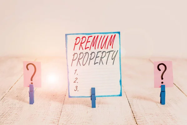 Writing note showing Premium Property. Business concept for upfront payment for a things belonging to someone Crumbling sheet with paper clips placed on the wooden table