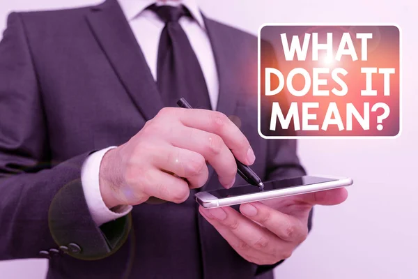 Writing note showing What Does It Mean question. Business photo showcasing Give me the meaning of something Definition Male human wear formal work suit hold smartphone using hand. — 스톡 사진