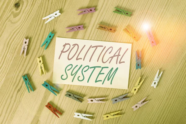 Text sign showing Political System. Business photo showcasing the process for making official government decisions Colored clothespin papers empty reminder wooden floor background office