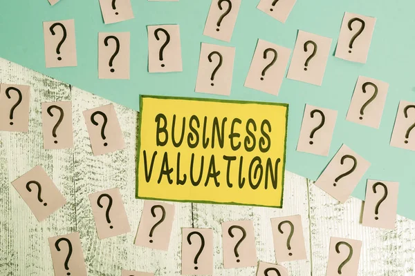 単語の書き込みテキストビジネス評価 事業全体の経済的価値を決定する事業写真表の上に厚紙で筆記 砕いた紙 — ストック写真