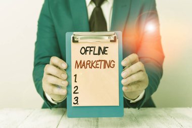 Writing note showing Offline Marketing. Business photo showcasing Advertising strategy published outside of the internet Man holds empty paper with copy space in front of him Space.