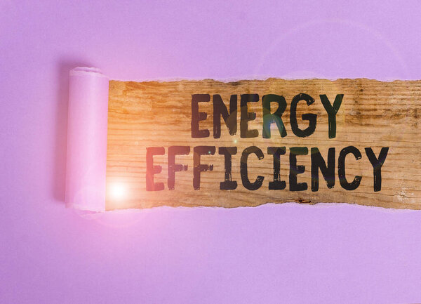 Handwriting text Energy Efficiency. Conceptual photo reduce the amount of energy required to provide product Cardboard which is torn in the middle placed above a wooden classic table