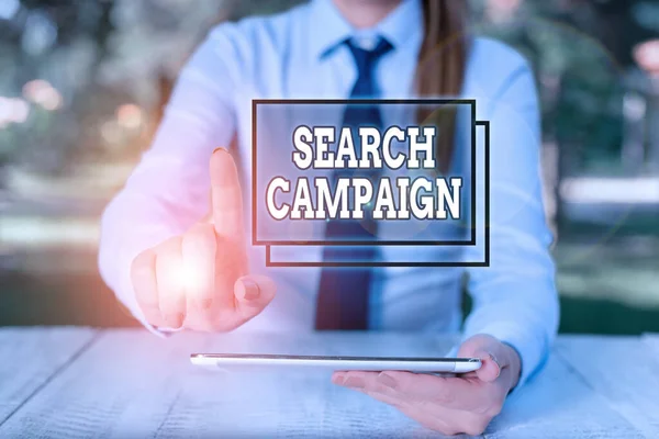 Conceptual hand writing showing Search Campaign. Business photo text method of placing online advertisements on web pages Female business person sitting by table and holding mobile phone. — Stok fotoğraf
