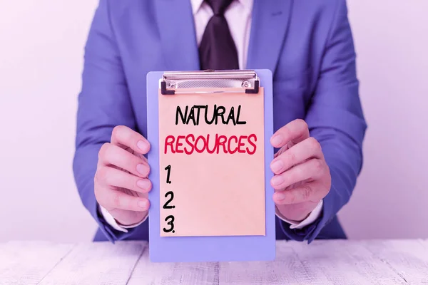 Writing note showing Natural Resources. Business photo showcasing materials that occur in nature and used for economic gain Man holds empty paper with copy space in front of him Space.