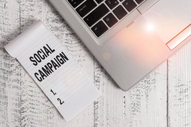 Sosyal Kampanya 'nın el yazısı metni. Marka bilincini artırmak için sosyal medya platformu kavramsal fotoğraf kullanımı. Üst düzey metalik dizüstü bilgisayar, yalan söyleyen, eski tip bir not defteri.