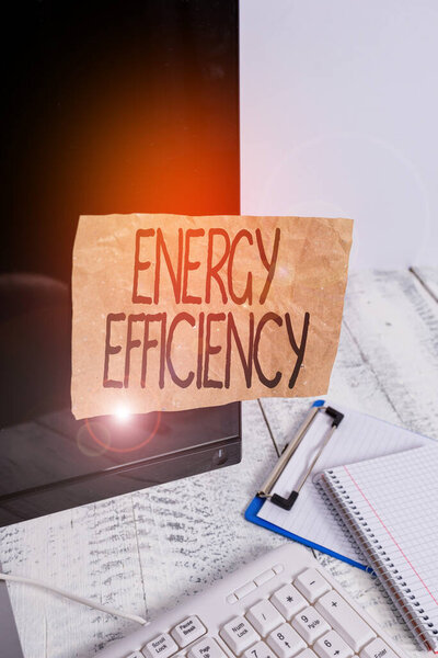 Conceptual hand writing showing Energy Efficiency. Concept meaning reduce the amount of energy required to provide product Note paper taped to black screen near keyboard stationary
