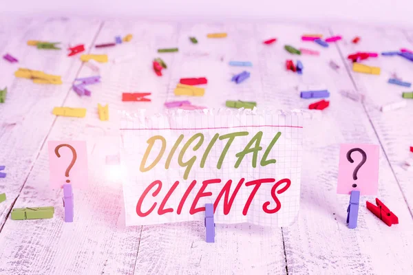 Writing note showing Digital Clients. Business concept for use digital channels to consume content or engage with brand Crumbling sheet with paper clips placed on the wooden table