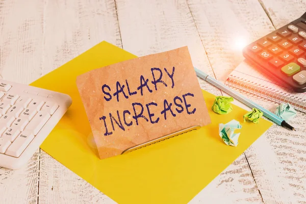 Writing note showing Salary Increase. Business concept for an increase in the salary or pay given to an employee Notepaper on wire in between computer keyboard and sheets