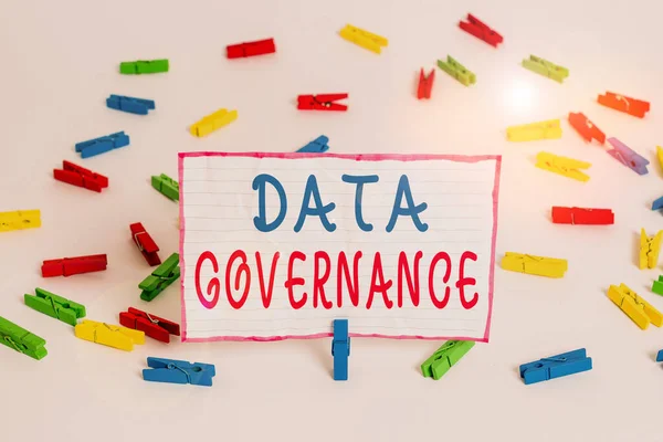 Conceptual hand writing showing Data Governance. Concept meaning general management of key data resources in a company Colored clothespin papers empty reminder white floor office