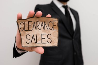 Text sign showing Clearance Sales. Business photo text goods at reduced prices to get rid of superfluous stock Male human wear formal work suit office look hold notepaper sheet use hand clipart