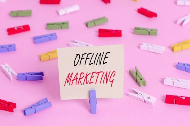 Çevrimdışı Pazarlamayı gösteren bir not yazıyorum. Reklam stratejisi için iş konsepti İnternet dışında yayınlandı Renkli çamaşır iğnesi kağıtları boş hatırlatıcı pembe ofis broşu