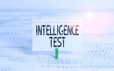 Zeka Testi 'ni gösteren bir not yazıyorum. Düşünme ve düşünme yetisini ölçmek için tasarlanmış iş konsepti. Yeşil mandal beyaz ahşap arka plan hatırlatıcı ofis malzemesi