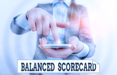 Dengeli Puan Kartı 'nı gösteren kavramsal el yazısı. İş fotoğrafı metni stratejik analizde kullanılan performans analizi metriği. İş kadını dokunmatik ekranı işaret ediyor.