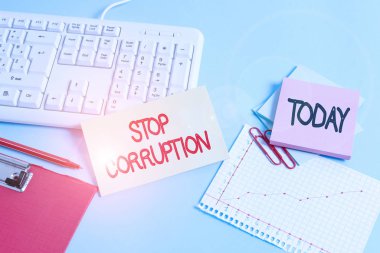 El yazısı Yolsuzluğu Durdur mesajı. Kavramsal fotoğraf Özel kazanç için verilen yetkinin kötüye kullanılmasına son verdi Kağıt mavi masa bilgisayarı klavye ofis çalışma defteri çizelge numaraları notu