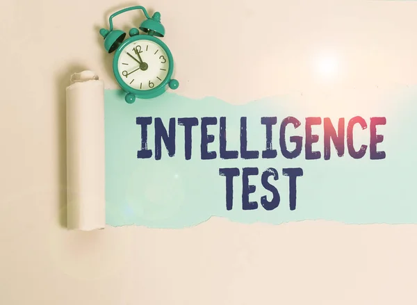 Writing note showing Intelligence Test. Business concept for test designed to measure the ability to think and reason Alarm clock and torn cardboard placed above plain pastel table backdrop