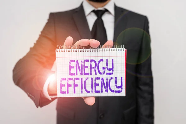 书写能源效率的文字。概念的意思是减少提供产品所需的能量男人穿正式的工作服办公室装束手持数学书籍. — 图库照片
