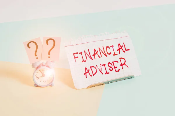 Text sign showing Financial Adviser. Business photo text demonstrating who is employed to provide financial services Mini size alarm clock beside a Paper sheet placed tilted on pastel backdrop