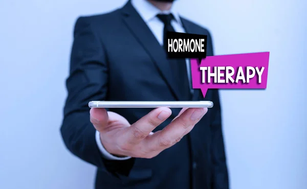 Writing note showing Hormone Therapy. Business photo showcasing treatment of disease with synthetic derived hormones Male human wear formal work suit hold smartphone using hand. — Stock Photo, Image
