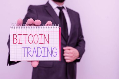 Conceptual hand writing showing Bitcoin Trading. Concept meaning buying and selling of cryptocurrency in stocks market Male human wear formal work suit with office look hold book