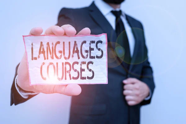 Word writing text Languages Courses. Business concept for set of classes or a plan of study on a foreign language Male human wear formal work suit office look hold notepaper sheet use hand.