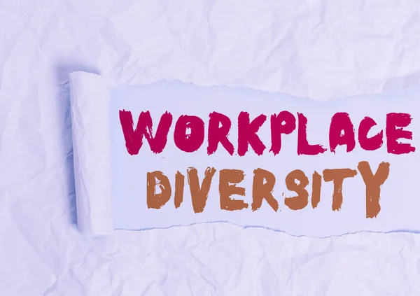 Word writing text Workplace Diversity. Business photo showcasing environment that accepts each individual differences Cardboard which is torn in the middle placed above a plain table backdrop