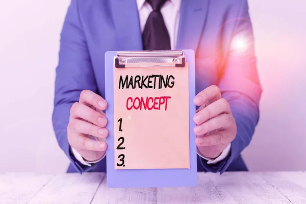 Writing note showing Marketing Concept. Business photo showcasing the strategy that firms adopt to satisfy customers Man holds empty paper with copy space in front of him Space.