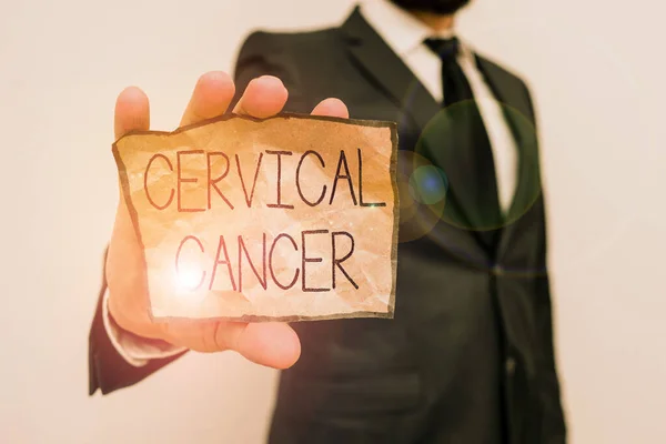 Text sign showing Cervical Cancer. Business photo text type of cancer that occurs in the cells of the cervix Male human wear formal work suit office look hold notepaper sheet use hand