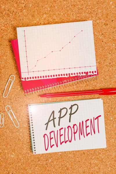 Text sign showing App Development. Business photo showcasing the act or process by which a mobile app is developed Desk notebook paper office cardboard paperboard study supplies table chart