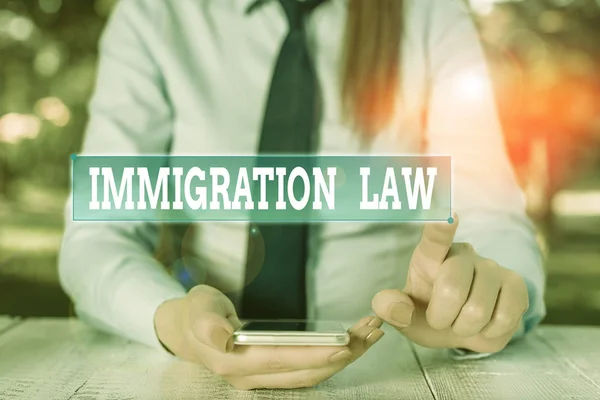 Käsiala Maahanmuuttolaki. Käsite, jolla tarkoitetaan maahanmuuttoa säänteleviä kansallisia sääntöjä ja oikeudellisia ennakkotapauksia Naispuolinen yrittäjä, joka istuu pöydän ääressä ja pitää matkapuhelinta . — kuvapankkivalokuva