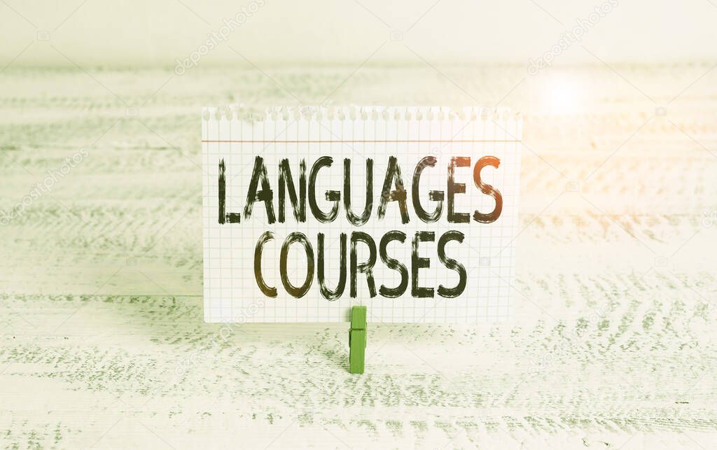 Writing note showing Languages Courses. Business concept for set of classes or a plan of study on a foreign language Green clothespin white wood background reminder office supply