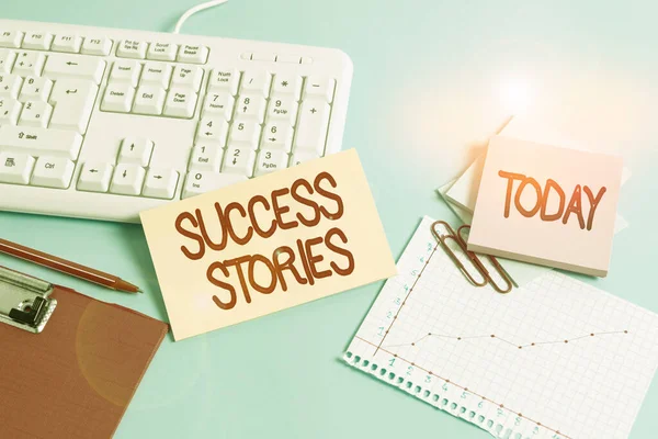 Handwriting text Success Stories. Conceptual photo story of something or someone that achieves great success Paper blue desk computer keyboard office study notebook chart numbers memo