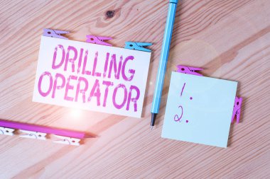 El yazısı sondaj operatörü. Kavramsal fotoğraf, donanım ve sondaj işlemlerini yapan biri. Renkli çamaşır iğnesi kağıtları boş, ahşap zemin ofisini anımsatıyor.