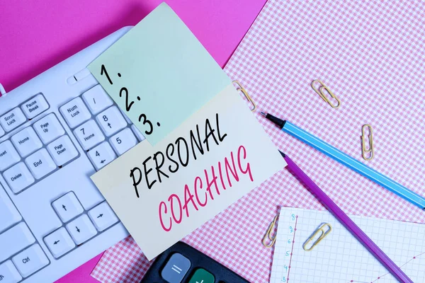 Text sign showing Personal Coaching. Business photo showcasing relationship agreement between a client and a coach Note paper stick to computer keyboard near colored gift wrap sheet on table